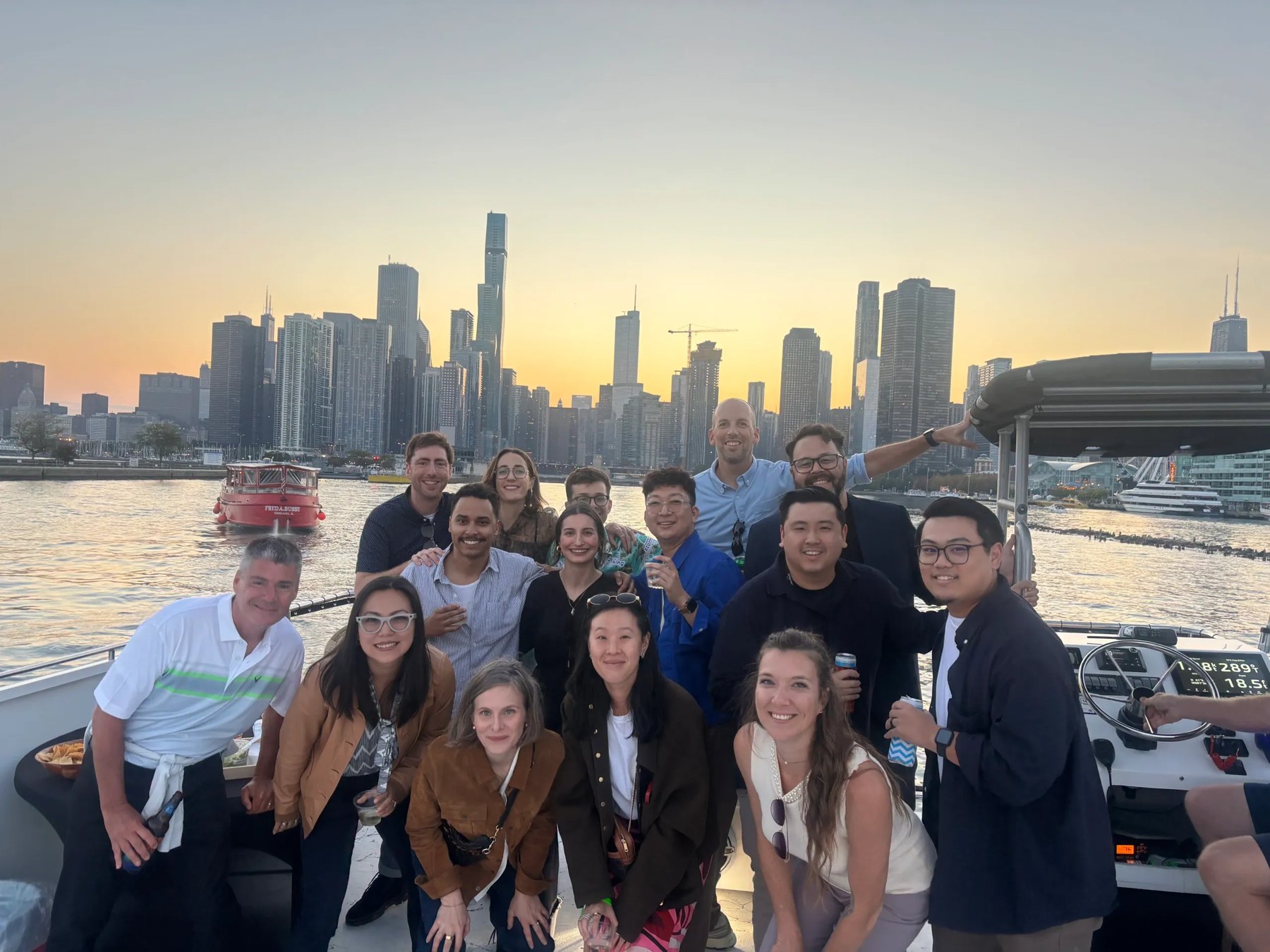 Members on a sunset boat outing with the Chicago skyline behind them